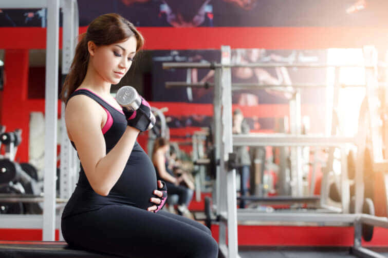ジムで運動する妊婦。妊娠中の健康と健康的なライフスタイル。3学期の間におなかが大きい妊婦の女の子がスポーツに出掛ける