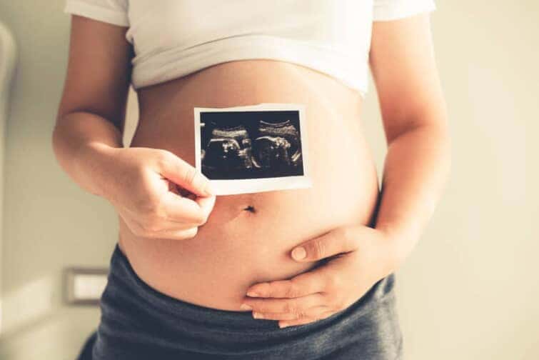 妊娠中の女性とおなかの胎児のエコー写真