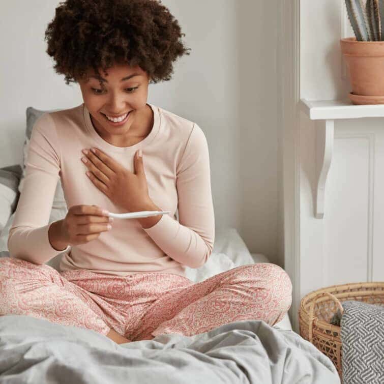 新しい人生の始まりだ！明るいアフリカ系アメリカ人の未来の母親は、妊娠検査で良い結果を信じられず、朝早く目覚め、寝室の内装に対してカジュアルなパジャマを着用する