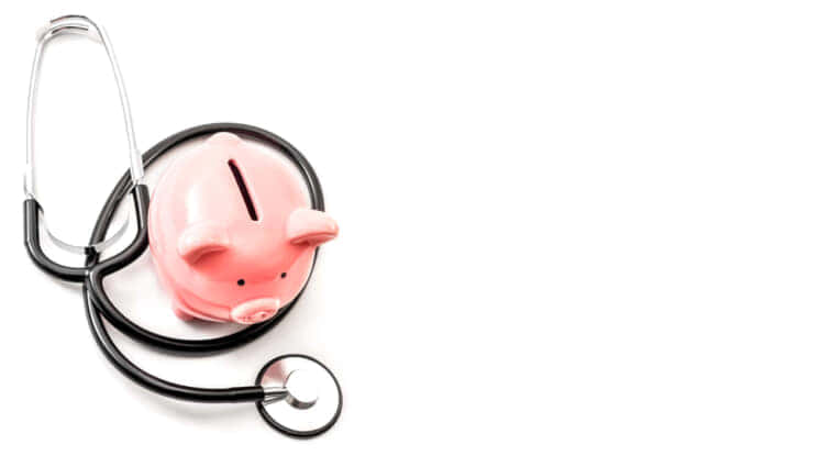 白い背景に医療費と高価な医療保険のコンセプトのテーマ、聴診器とコピー用スペースとピンクの豚小屋