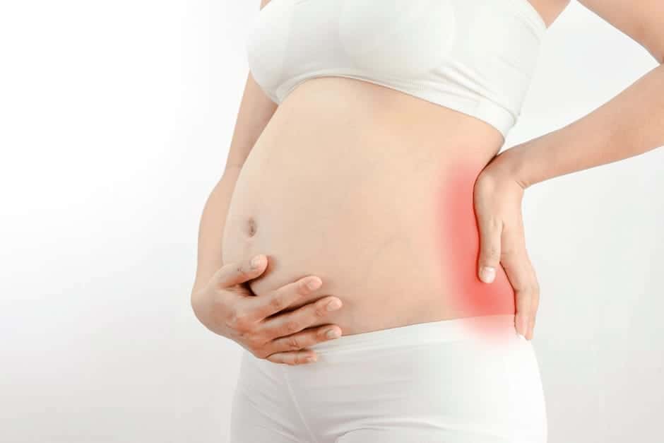 腰が痛くておさえている妊娠中期の女性