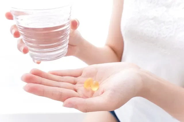 サプリメント・薬を飲む女性