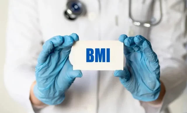 手袋をはめた医療従事者が、略語 BMI (Body Mass Index) のカードを持っています。 医療コンセプト