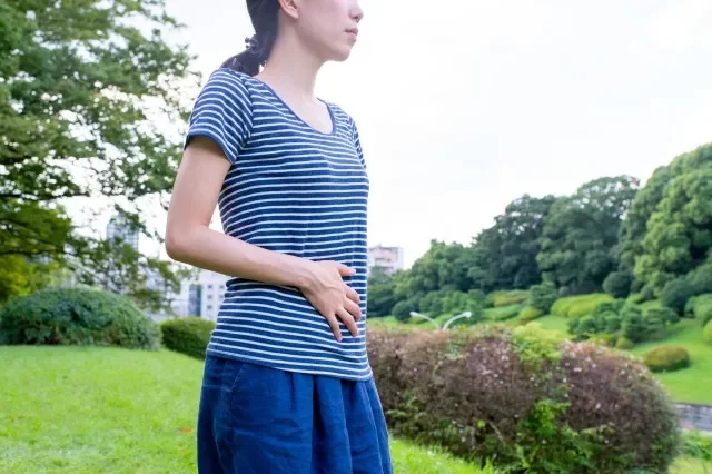 下腹部を押さえる女性