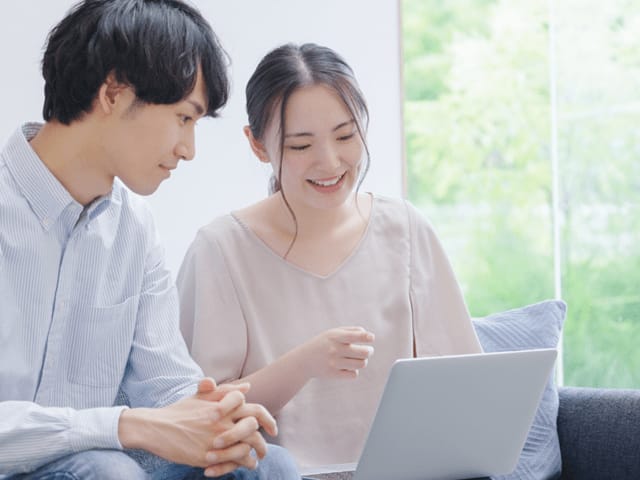 パソコンを見て話している夫婦