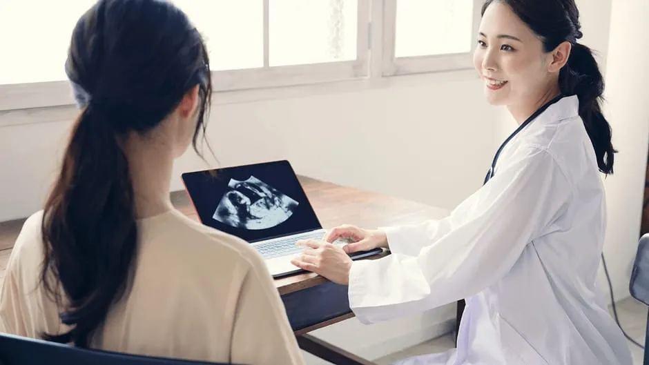 妊娠しているどうか検査の結果を患者さんに伝えている女性医師