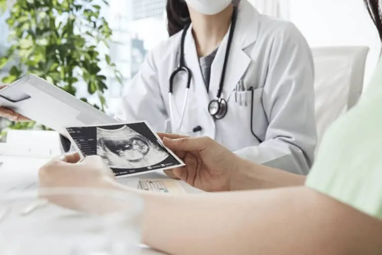 医師と胎児の超音波写真と妊婦