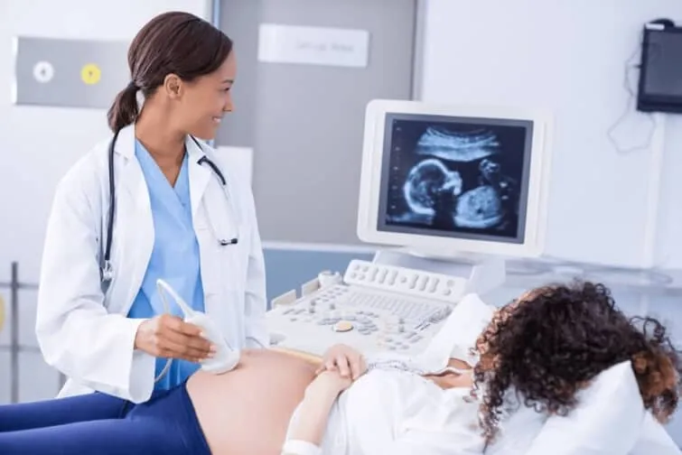 ﾁｮ音波検査中の医師と妊婦
