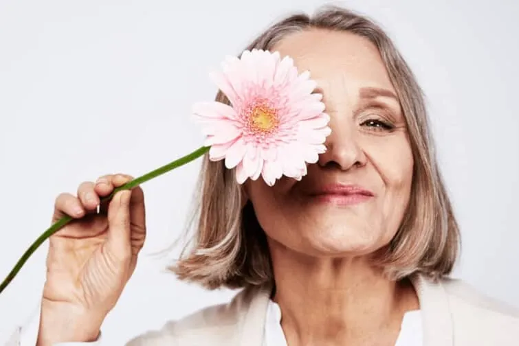 花を持つ高齢の女性