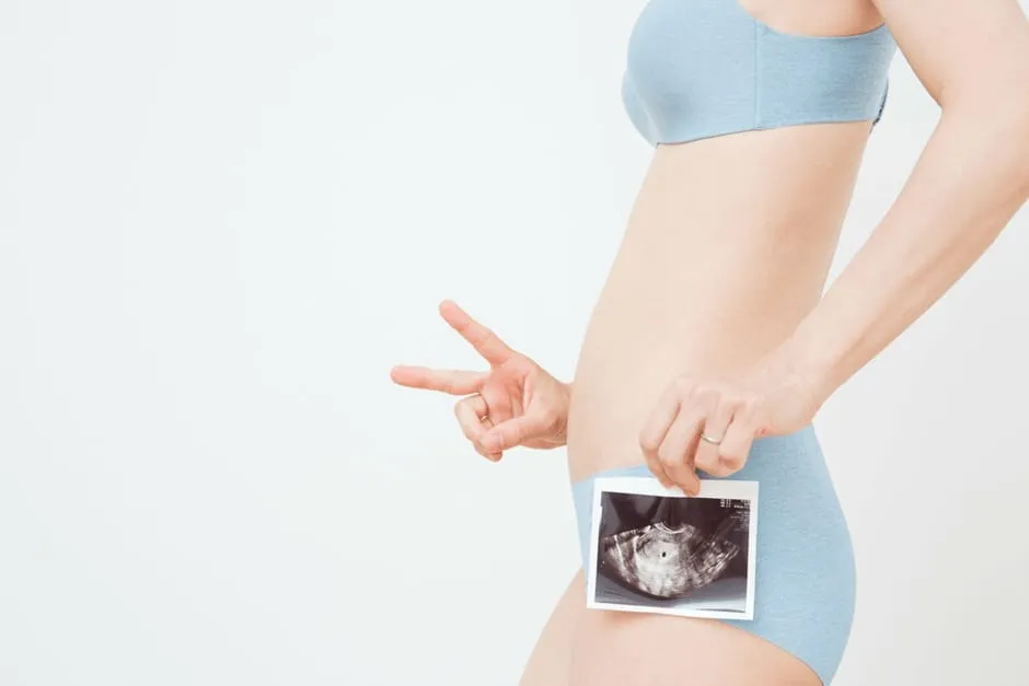 超音波エコー検査で胎嚢の確認ができてVサインをしている女性