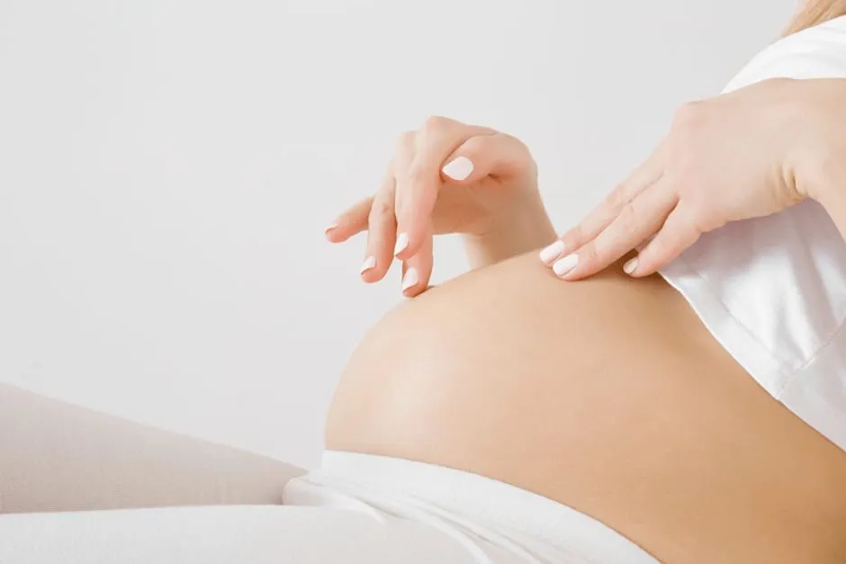 お腹の張りがひどくて横になっている妊娠中期の女性