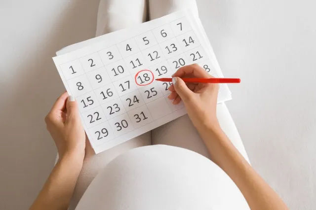 若い妊婦は、カレンダーで出産日をマークします。 コンセプトを期待している赤ちゃん。 将来の計画。 視点翔