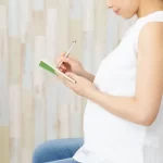 母子手帳にメモをしている妊婦さん