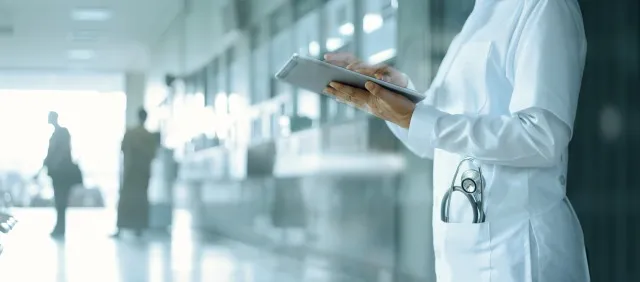 ヘルスケアと医学。 医療と技術。 病院の背景にデジタル タブレットに取り組んでいる医師