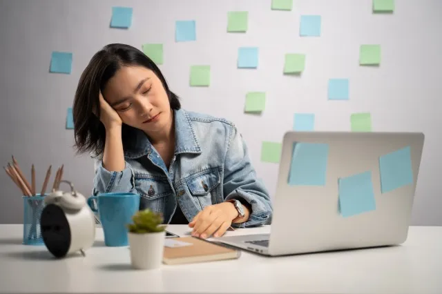 ノートパソコンで作業するアジア人女性は、疲れてホームオフィスで昼寝をします。 WFH。 在宅勤務。 予防コロナウイルス COVID-19 コンセプト