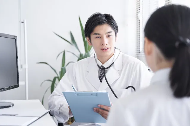 女性会社員を診察する日本人男性ドクター