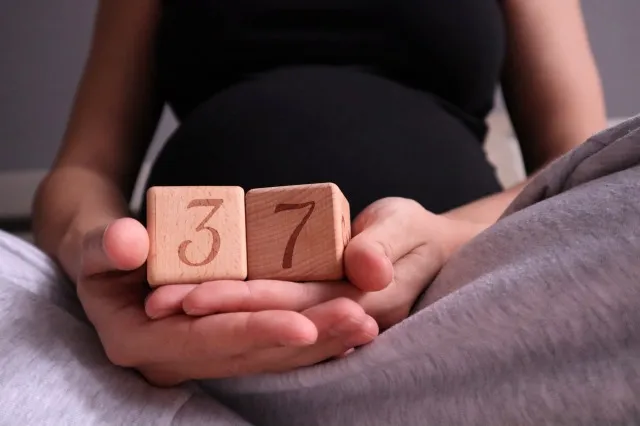 キューブを保持している妊娠 37 週の妊婦