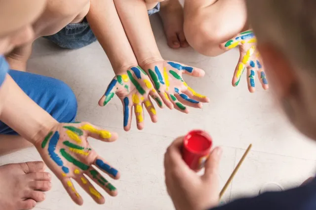 先生はモンテッソーリ法に従って子供たちと働き、手を描きます。 自閉症スペクトラム障害児との幼稚園教師療法セッション