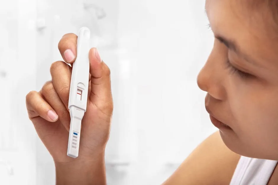 妊娠検査薬の結果をおそるおそる見ている女性