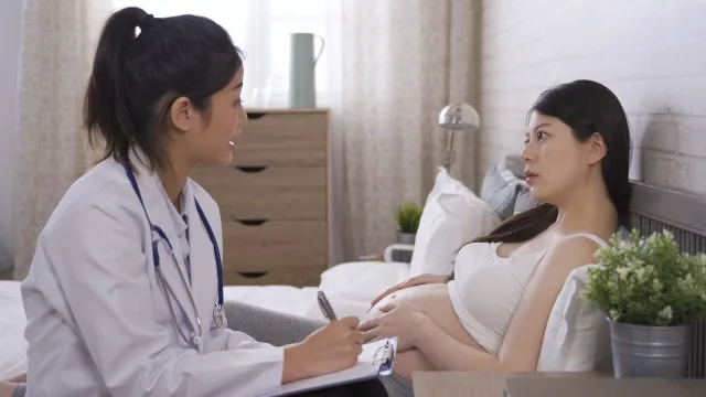妊娠中の腹の硬さと締め付けを体験したことを描いたアジア人の女性