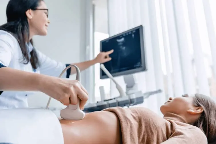腹部超音波検査を受ける女性と実施する医師