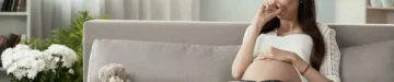 妊娠中のお腹を押さえて悲しむ女性