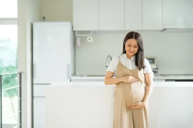 キッチンの前に立つ妊婦