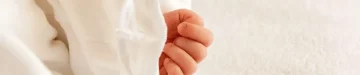 白いベビー服を着て横になっている赤ちゃん