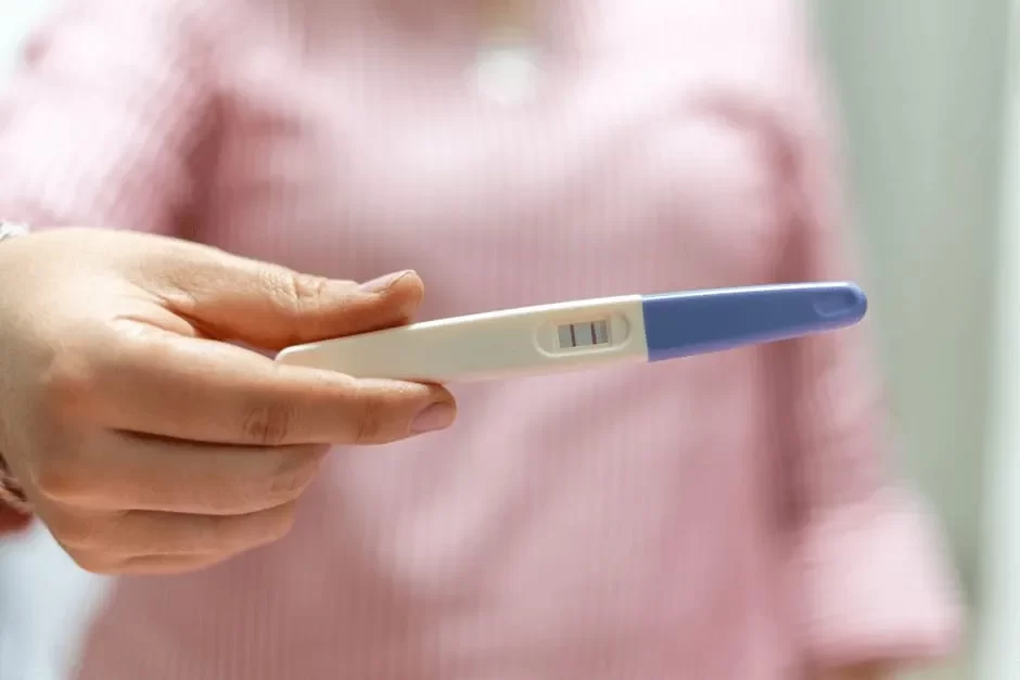 妊娠検査薬の結果を見せる女性