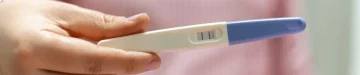 妊娠検査薬の結果を見せる女性