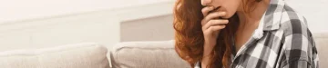 妊娠検査薬で予想外の結果が出て驚いている女性