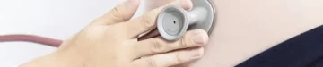 聴診器を妊婦のお腹に充てる助産師