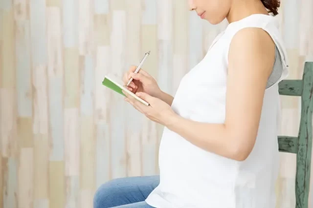 母子手帳にメモをしている妊婦さん