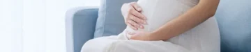 部屋でリラックスする若い妊婦